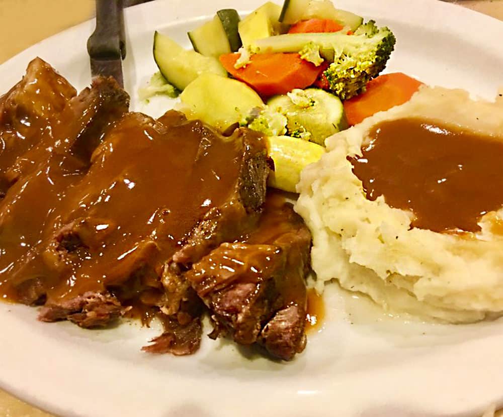 The pot roast at The Lighthouse Cafe & Deli in San Pedro, California, slathered with rich brown gravy and accompanied by mashed potatoes and steamed fresh vegetables