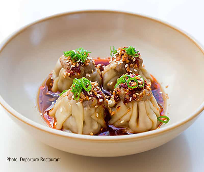 A bowl of pork dumplings in a rich brown sauce from Departure Restaurant, Portland, OR