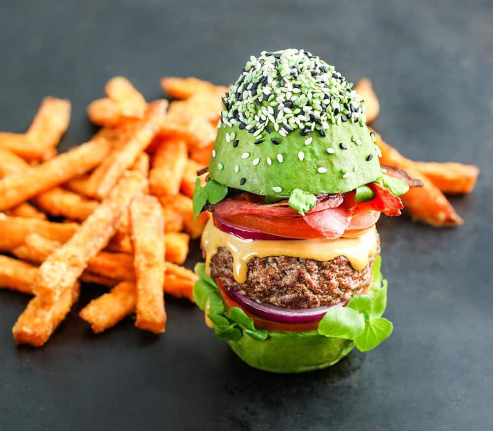 The Bun Burger, from The Avocado Show, replaces the bun with a whole avocado, cut in half crosswise and filled with Angus beef, lettuce, tomato, bacon and cheese.