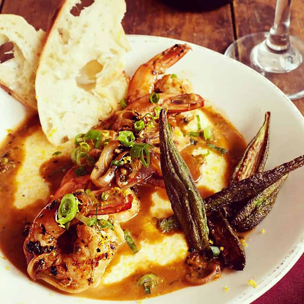 A heaping plate of shrimp and grits, with fresh bread and crispy okra, from Over Yonder Restaurant in Valle Crucis, North Carolina.