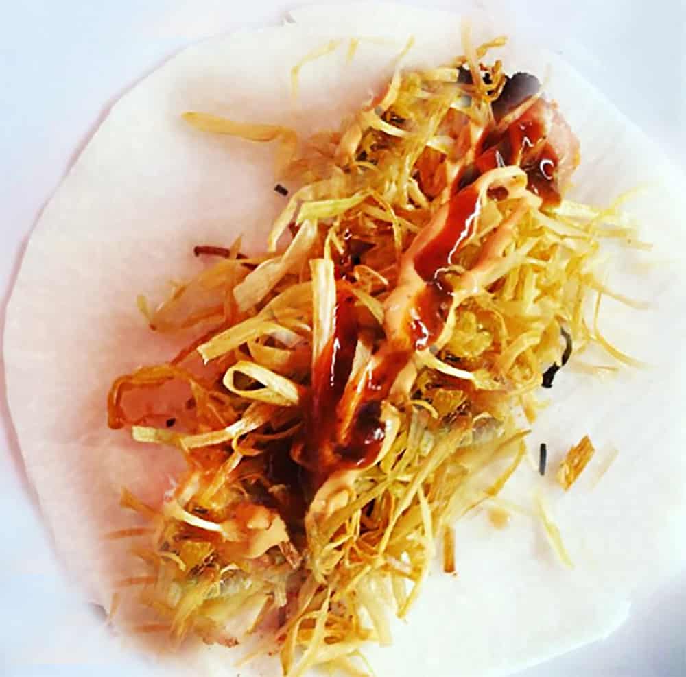 A jicama taco, the signature dish of La Azotea Tapas Bar & Lounge in San Miguel de Allende. It shows the thinly sliced jicama that replaces the tortilla, topped with fried shrimp and crispy frizzled leek.